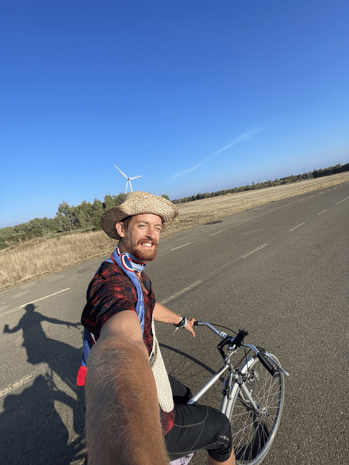 Milio con cappello di paglia in sella alla bici